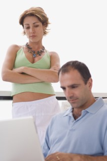 Man using laptop while woman watches