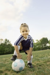 Young girl in athletic gear with soccer ball
