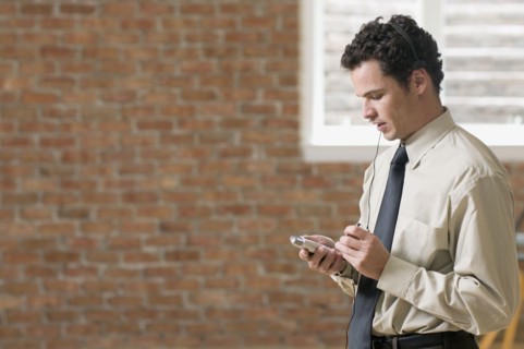 Businessman using PDA with head set