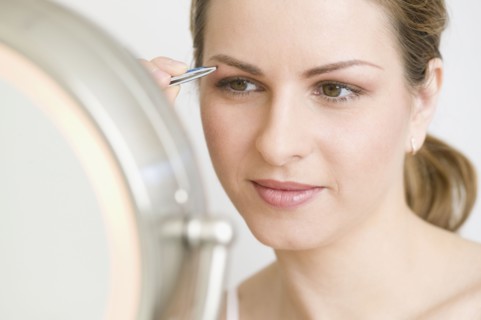Hungarian woman tweezing eyebrows