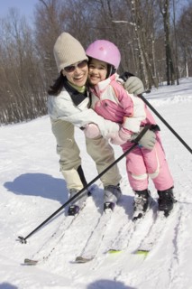 Mother and daughter smiling on skis