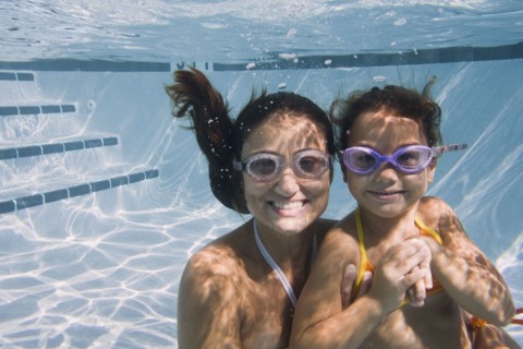 Mother and daughter swimming in swimming pool