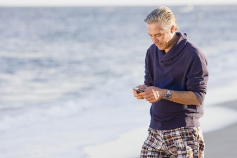 Man using cell phone on beach