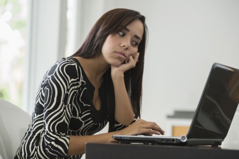 Mixed race businesswoman typing on laptop