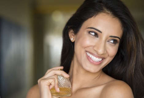 Indian woman spraying perfume on neck