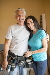 Smiling contractor hugging wife