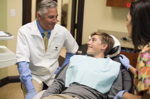 Dentist and nurse talking to patient