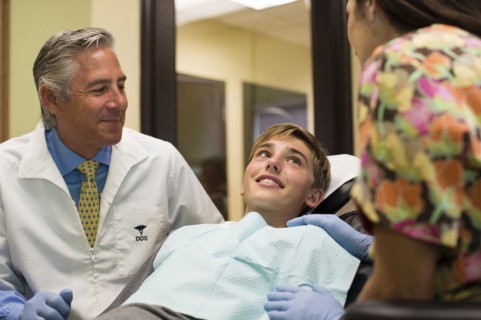 Dentist and nurse talking to patient