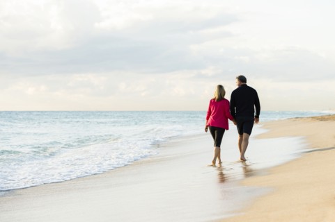 Caucasian couple walking on beach