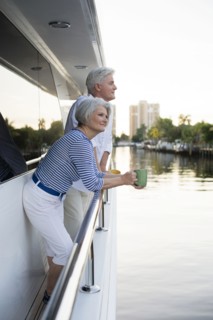 Older Caucasian couple having coffee on boat deck