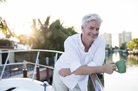 Older Caucasian having coffee on boat deck