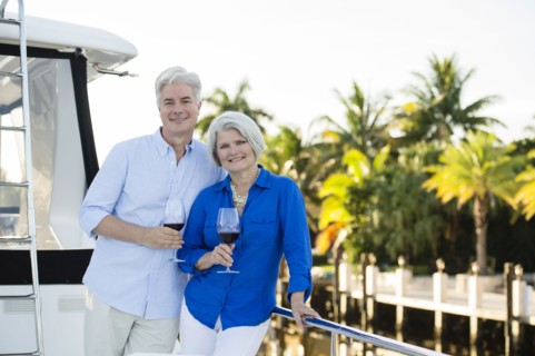 Older Caucasian couple having wine on boat deck