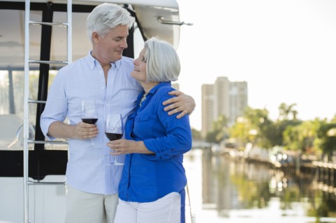 Older Caucasian couple having wine on boat deck