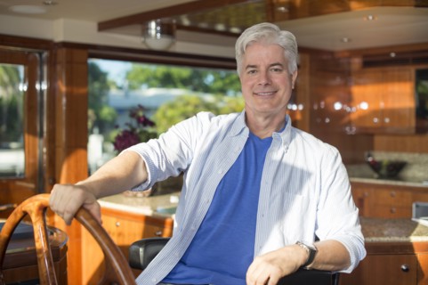 Older Caucasian man steering yacht