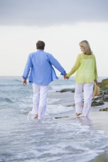 Caucasian couple walking on beach