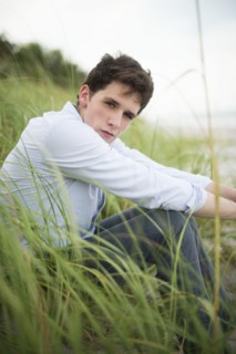 Hispanic man sitting in tall grass