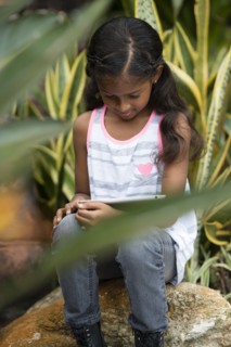 Mixed race girl using digital tablet outdoors