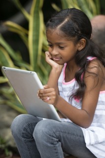 Mixed race girl using digital tablet outdoors
