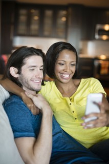 Couple taking self-portrait on sofa