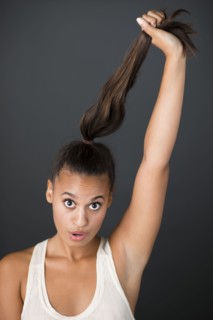 Mixed race woman pulling her ponytail