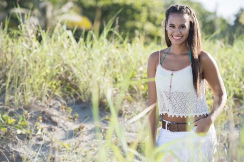 Mixed race woman smiling in tall grass