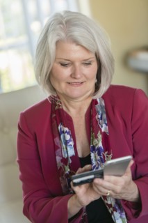 Caucasian older woman shopping online with cell phone