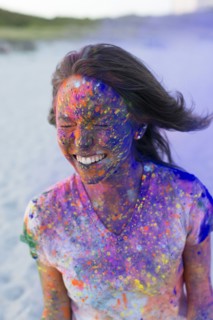 Caucasian woman splattered with paint powder with eyes closed