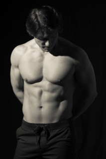 Hispanic man with bare chest looking down