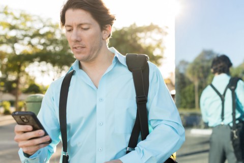Hispanic businessman texting on cell phone outdoors