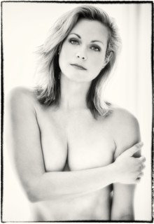 Nude Caucasian woman covering her breasts