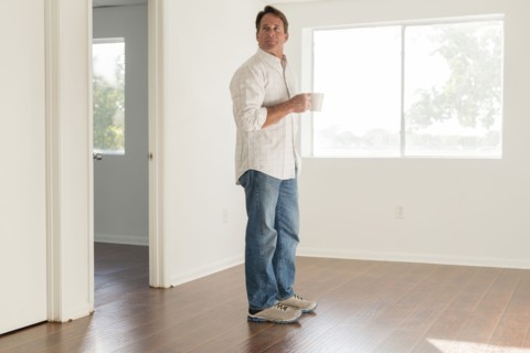 Caucasian man drinking cup of coffee in empty room