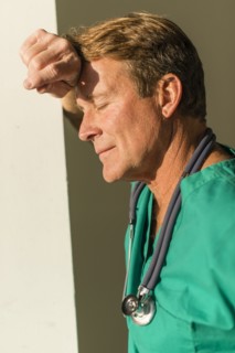 Stressed Caucasian nurse leaning on wall