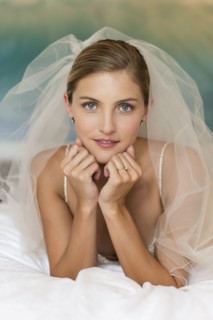 Caucasian bride in wedding veil leaning on elbows