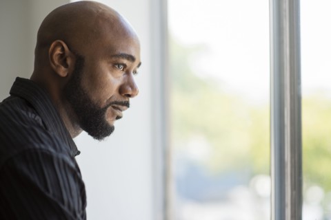 Black man looking out window