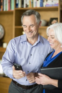 Caucasian couple using cell phone in living room