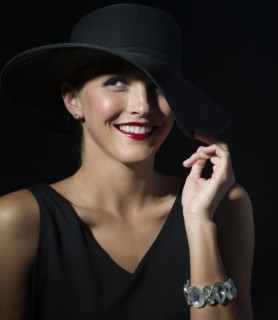 Stylish Caucasian woman wearing black hat and dress