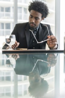 Hispanic businessman using cell phone at conference table