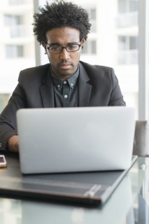 Hispanic businessman using laptop in office