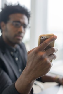 Hispanic businessman using cell phone in office