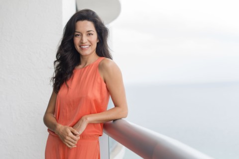 Hispanic woman leaning on balcony