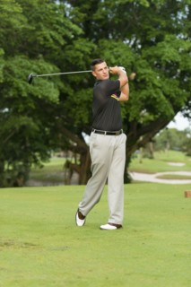 Caucasian man swinging club on golf course