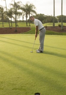 Caucasian man putting on golf course