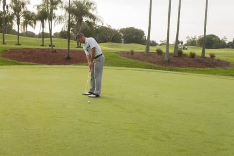 Caucasian man putting on golf course