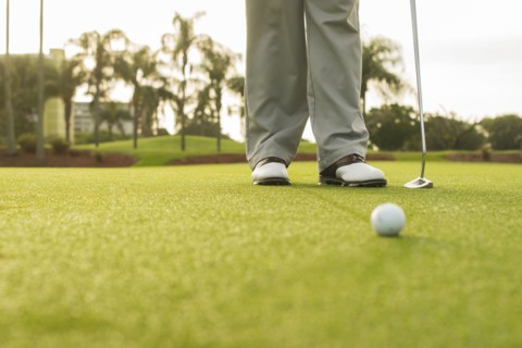 Caucasian man standing on golf course green