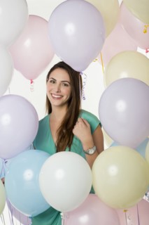 Hispanic woman standing with balloons