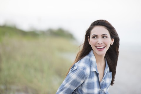 Hispanic woman smiling on beach