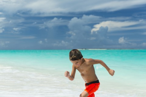 Hispanic boy playing on beach