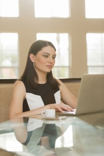 Hispanic businesswoman using laptop in office