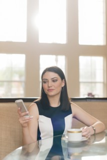 Hispanic businesswoman using cell phone in office
