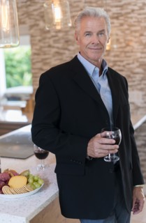 Caucasian man drinking wine in kitchen